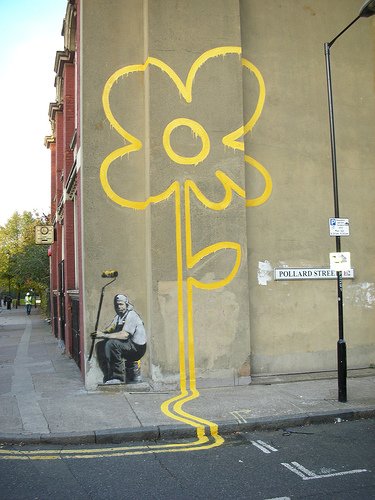 Photo of a Banksy image of double yellow lines extending from the street to a wall on Pollard Street