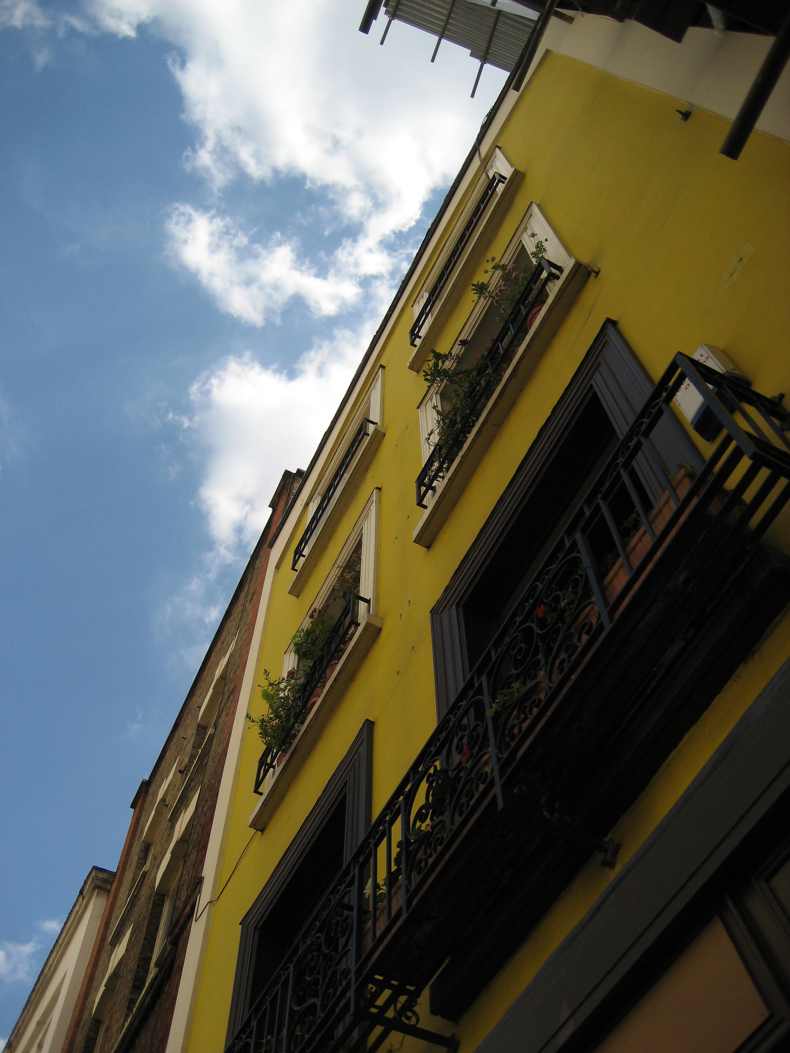 Photo of a yellow house angled in front of a blue sky